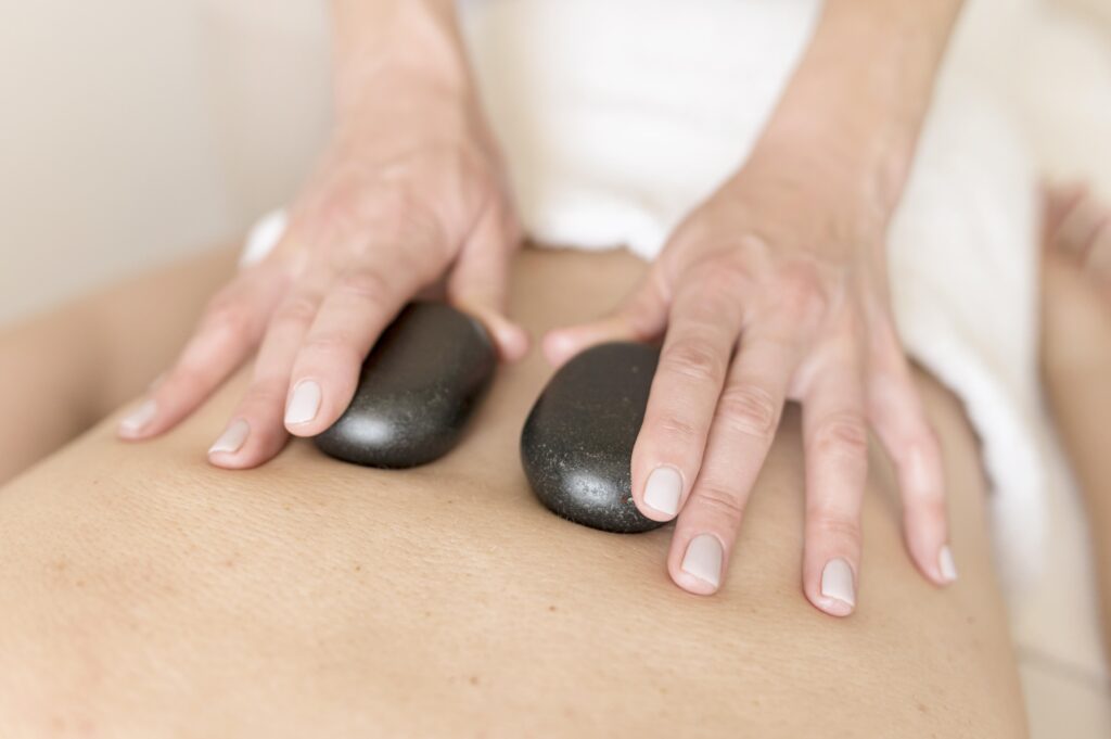 アロマリンパマッサージとホットストーンを使ったリラクゼーション施術"Aroma lymphatic massage with hot stones for relaxation."